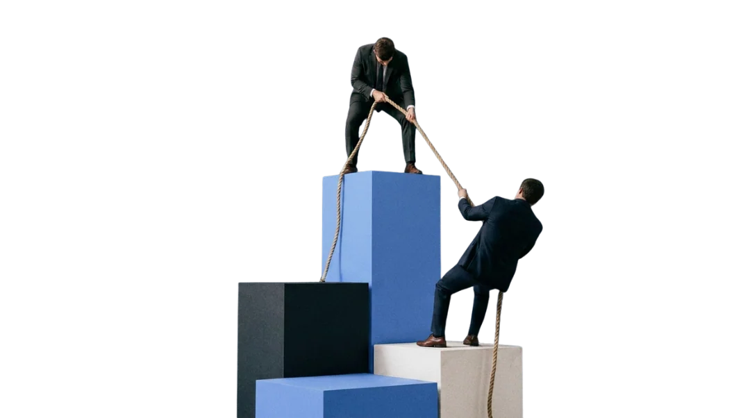 Két öltönyös alak kötéllel emel egy elemet a lépcsőn – keresőoptimalizálás